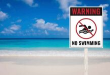 Rip Current Ambush at Aliso Beach No swimming warning sign on a tropical beach