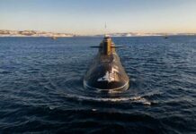 Submarine cruising on cold open water toward camera