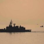 Insurance Panic Over Iran Lane naval ship silhouette at sea during sunset