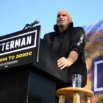 Speaker at outdoor rally standing at podium with microphone