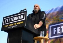 Unlikely Alliance Rattles Party Bosses Speaker at outdoor rally standing at podium with microphone