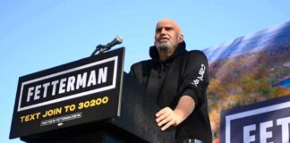 Speaker at outdoor rally standing at podium with microphone