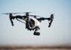 Quadcopter drone with camera flying outdoors