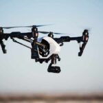 Quadcopter drone with camera flying outdoors