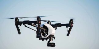 Quadcopter drone with camera flying outdoors