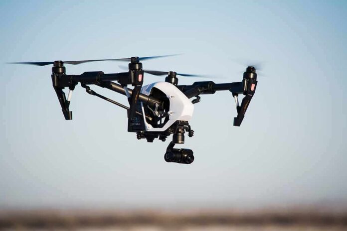 Quadcopter drone with camera flying outdoors
