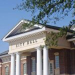 Dirty Word Allegation Rattles Mayor’s Office Exterior view of a city hall building with columns and a clear blue sky