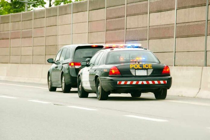 Police car with flashing lights stops a minivan on highway