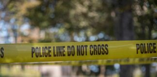 Mobile Park Standoff Turns Chaotic yellow police tape cordoning off an outdoor area