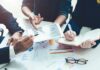 Panic Moves As Startups Flee Business meeting with hands pointing at tablet and taking notes