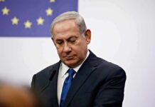 Walkout Drama Shadows Netanyahu man in suit at podium with EU flag in background