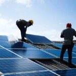 Workers installing solar panels on a rooftop