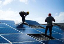 China’s Coal Kingpins Just Got Upstaged Workers installing solar panels on a rooftop