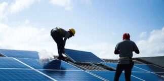 Workers installing solar panels on a rooftop