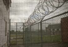 Barbed wire on chain-link fence at a prison yard