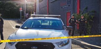 LA Mall Ambush Stuns Shoppers Police car behind yellow caution tape on a city street