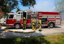 Four-Alarm Inferno Engulfs Hip Dining Strip Fire truck with firefighters operating hoses on a residential street