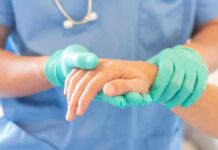 Illegal Care Claim Falls Apart Healthcare worker in gloves holding a patient's hand