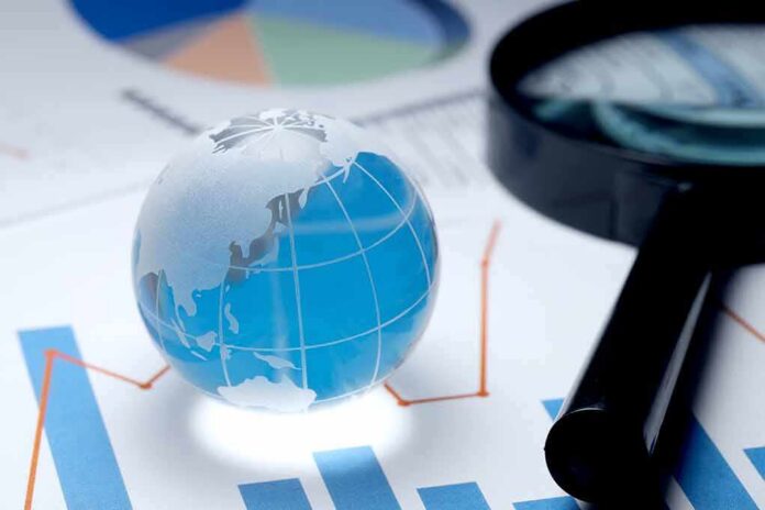 Glass globe on financial charts with magnifying glass