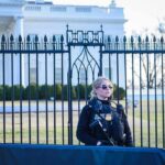 Security officer stands guard outside a large white government building