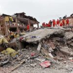 Nepal Rescue Saves After Nine Days Rescue workers in orange uniforms on a collapsed building site after an earthquake