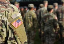 Soldier in camouflage with U.S. flag patch at formation