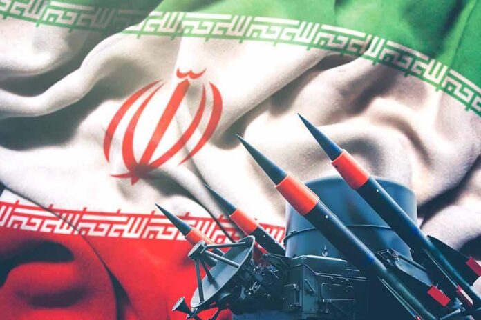 shutterstock_1628171845 Iranian flag behind a battery of missiles and radar equipment