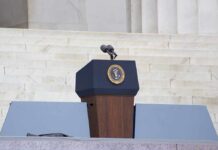 Podium with a microphone and presidential seal in front of steps