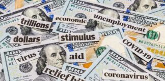 Hundred-dollar bills with cutout words about stimulus and economy