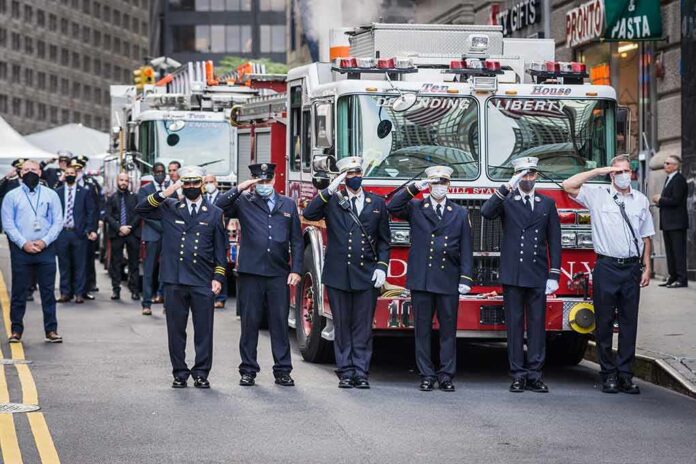 Firefighters in dress uniforms salute in front of fire trucks