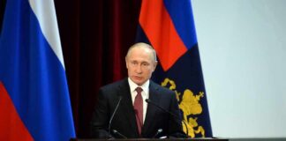Seven Insiders Emerge In Putin Succession speaker at podium with flags in background