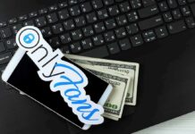 Smartphone with OnlyFans sticker and cash on a laptop keyboard