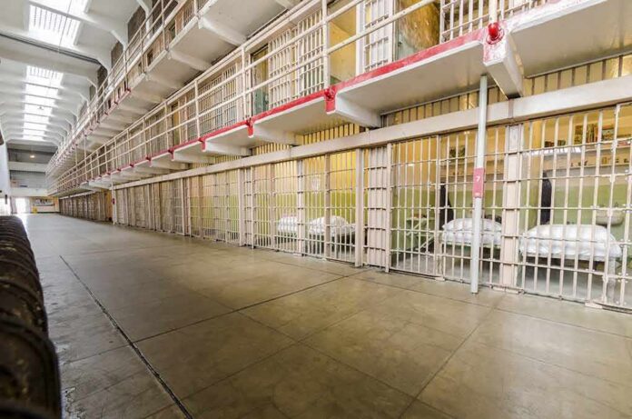 shutterstock_206534239 Prison cell block with barred doors and walkway