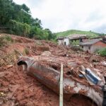 Tourists Vanish After Glacier Shock Landslide debris covering houses and a buried car on a muddy hillside