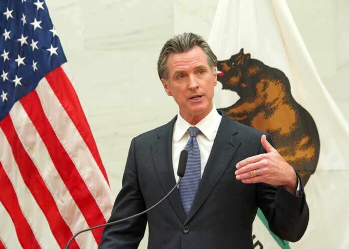 Gavin Newsom speaks at a podium with U.S. and California flags behind him
