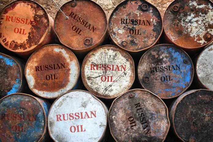 shutterstock_2152961219 Rusty oil barrels stacked in rows