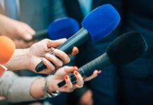 Mystery Rail Piece Triggers Mass-Casualty Derailment Reporters holding colorful microphones