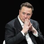 A-List Accusation Collides With Musk Denial man in a suit with hands clasped thoughtfully