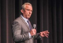 RFK Jr. Takes Aim At Democrats man in a suit speaking into a microphone on stage