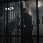 Hazing Dungeon Exposed at UW police officer at a jail cell with detainees behind bars