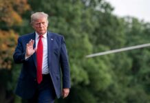 Donald Trump walking outdoors and waving