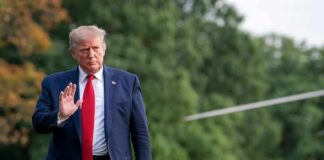 Donald Trump walking outdoors and waving