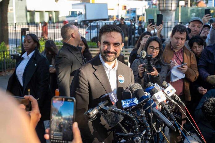 Democratic,New,York,City,Mayoral,Candidate,Zohran,Mamdani,Speaks,To Smiling man at outdoor press conference with microphones