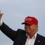 man in a red baseball cap waving