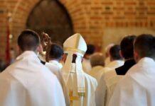 Bishop in white mitre among clergy during church procession