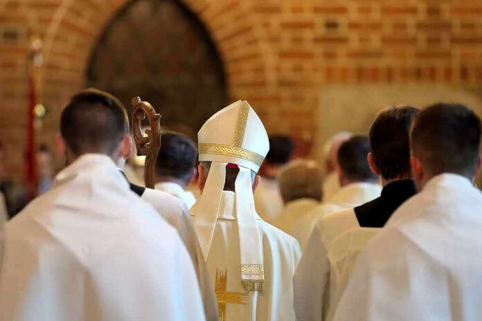 shutterstock_653291812 Bishop in white mitre among clergy during church procession