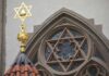 Star of David atop synagogue roof with stained glass window