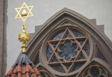 Star of David atop synagogue roof with stained glass window