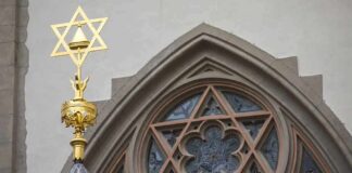 Star of David atop synagogue roof with stained glass window