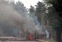 Burning vehicle on a smoke-filled street